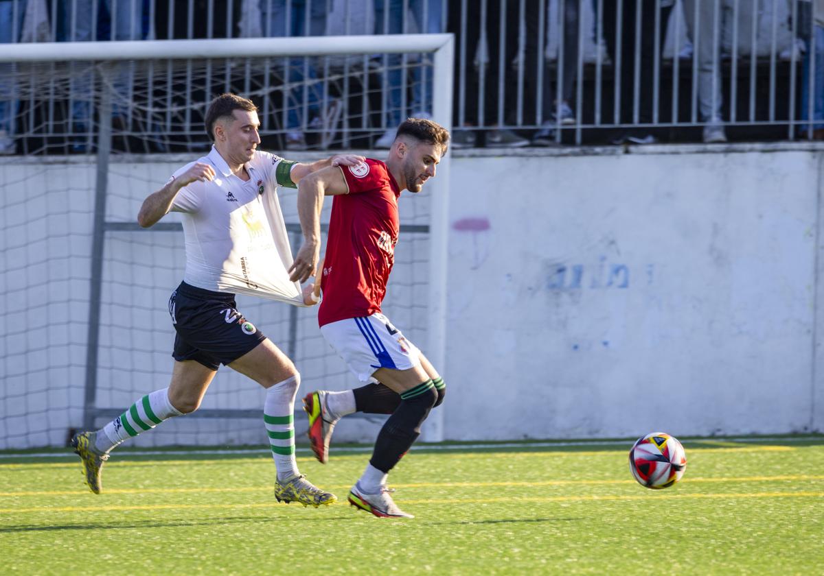 Gandarillas, del Rayo Cantabria (izquierda) pelea por la pelota con Rasines.