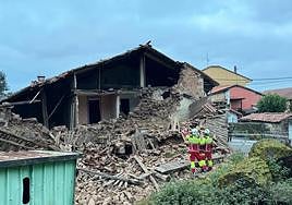 Varios operarios, este sábado, frente a los restos del derrumbe del inmueble.