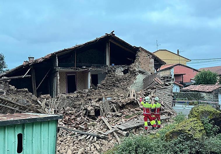 Varios operarios, este sábado, frente a los restos del derrumbe del inmueble.