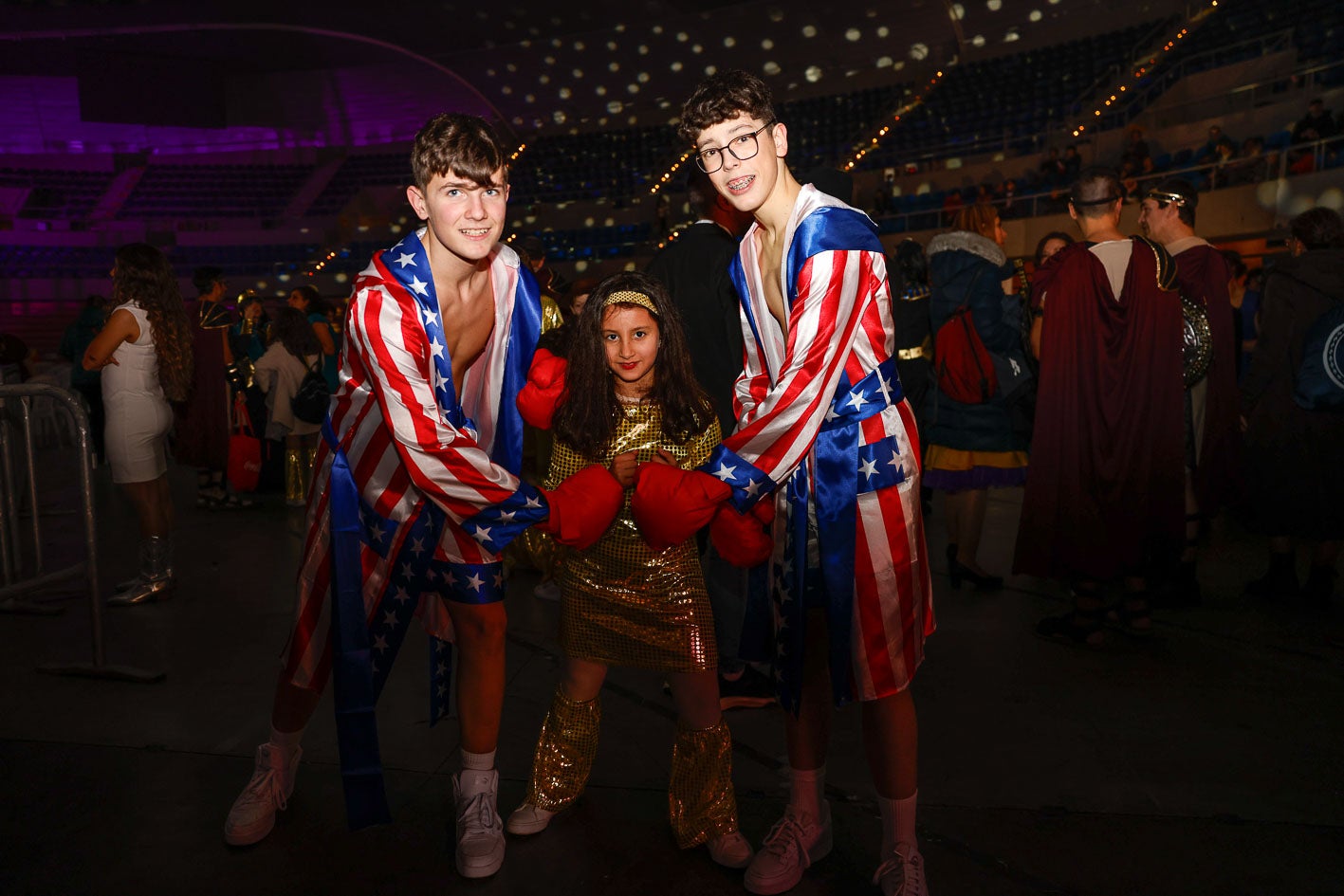 Tres niños disfrazados de boxeadores esperando el comienzo de la gala