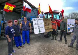 De izquierda a derecha, María Suárez, José Sainz, José Carlos Suárez, Manuel Sainz, Luis Herrero, Olivier Gómez y Carlos Díez, ganaderos de la zona occidental de Cantabria, muestran junto a sus tractores las pancartas preparadas para la protesta de hoy por las calles de Santander.