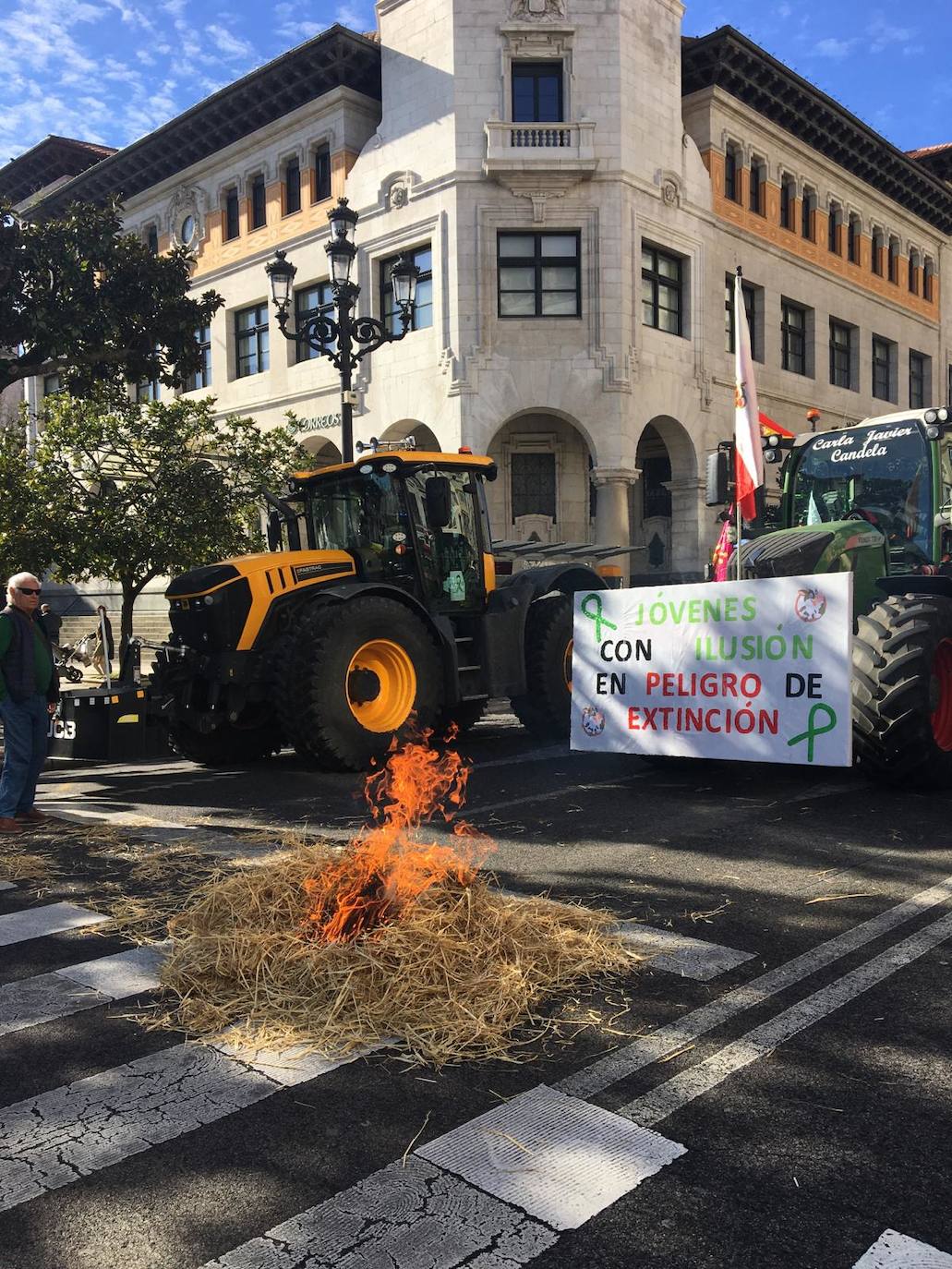 Imagen principal - Arriba, una pequeña hoguera con paja en la calle Calvo Sotelo. A la izquierda, un tractor, con un potro muerto, ha aparcado en el puerta de la Delegación del Gobierno. A la derecha, la marcha de los tractores por Santander.