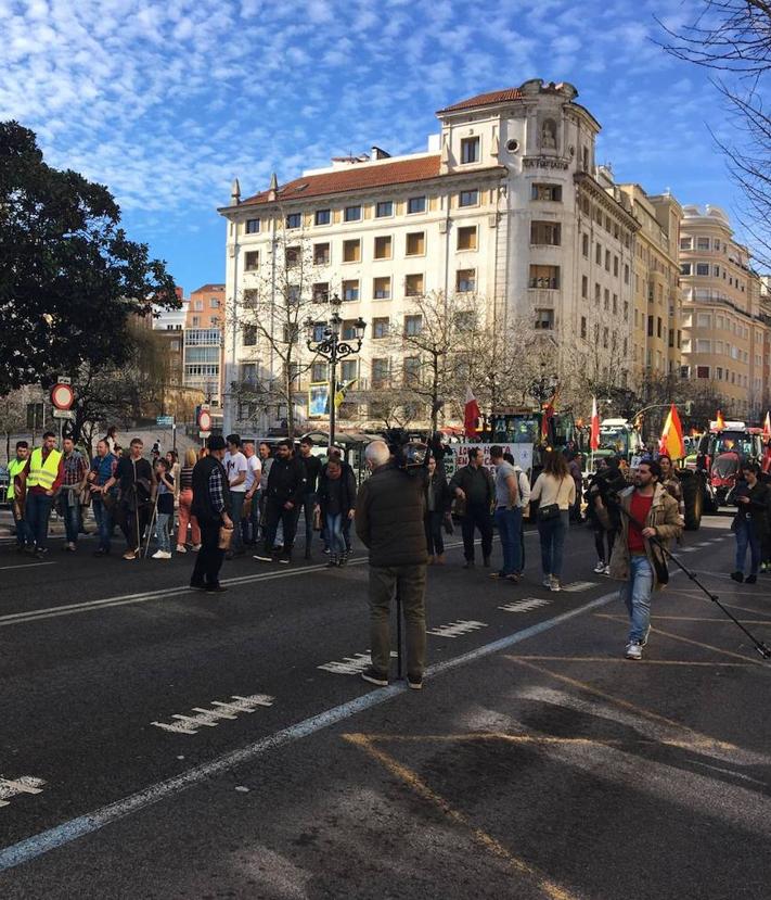 Imagen secundaria 2 - Arriba, una pequeña hoguera con paja en la calle Calvo Sotelo. A la izquierda, un tractor, con un potro muerto, ha aparcado en el puerta de la Delegación del Gobierno. A la derecha, la marcha de los tractores por Santander.