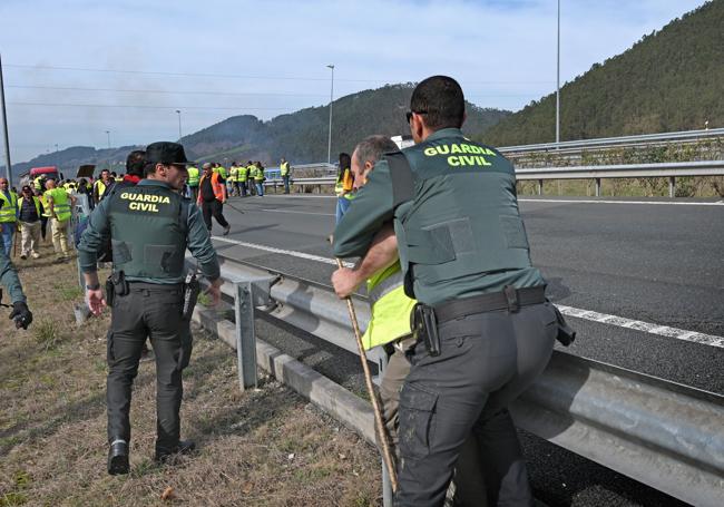 Un guardia civil trata de impedir a un manifestante acceder a la autovía