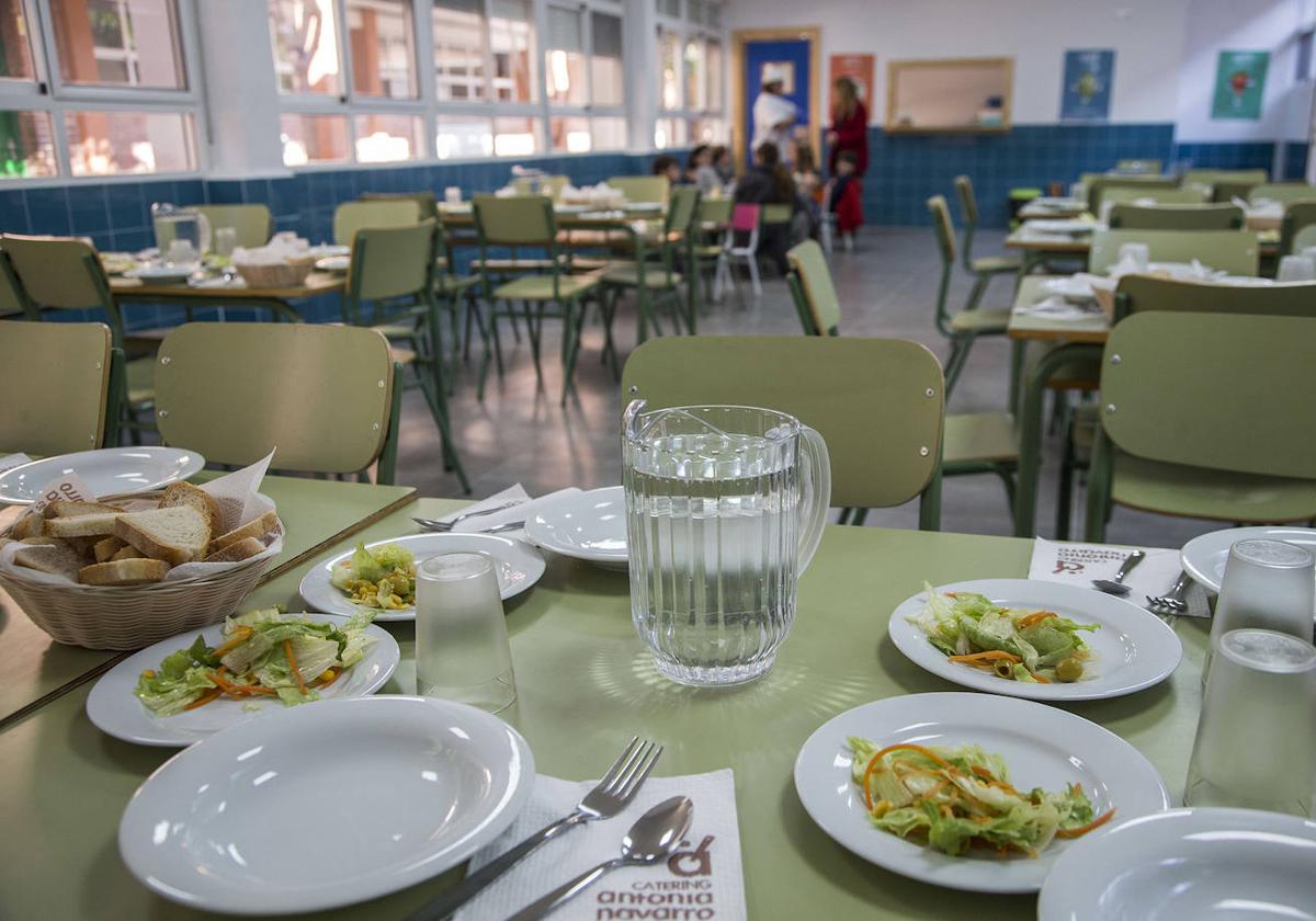 Un pequeño grupo de escolares, junto a dos cuidadoras, en el comedor de un centro educativo.