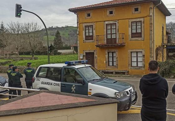 La Guardia Civil de Selaya y un miembro de la empresa Antiokupa Norte frente a la vivienda.