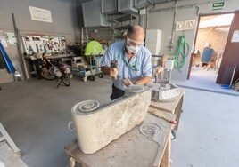 Un artesano trabaja la piedra en su taller.