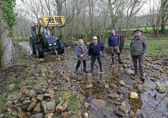 El ganadero de Ruente Pablo Gutiérrez, acompañado de otros afectados en un tramo del río Saja.