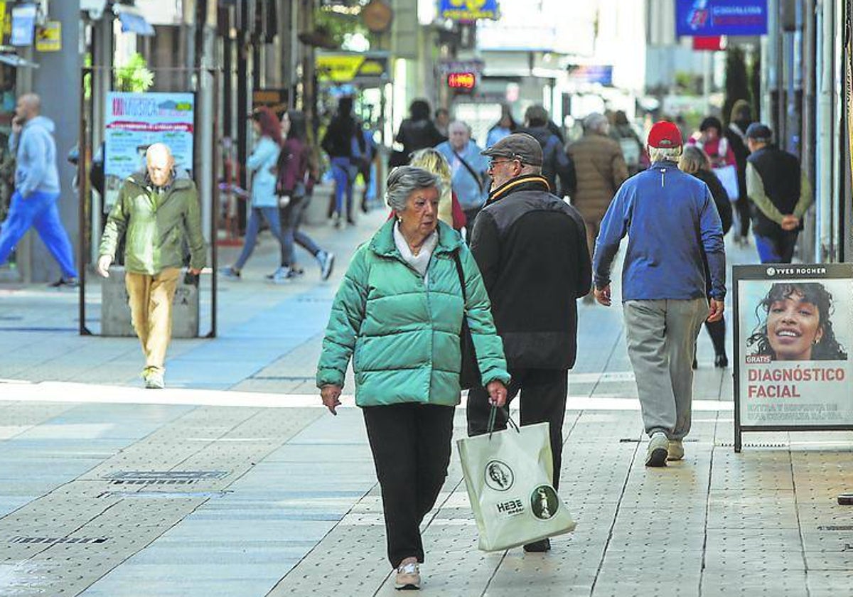 Vecinos caminan por la calle Consolación, en Torrelavega.