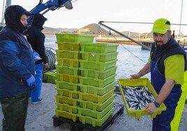 Dos pescadores del 'Siempre Landera' descargan los primeros kilos de bocarte.