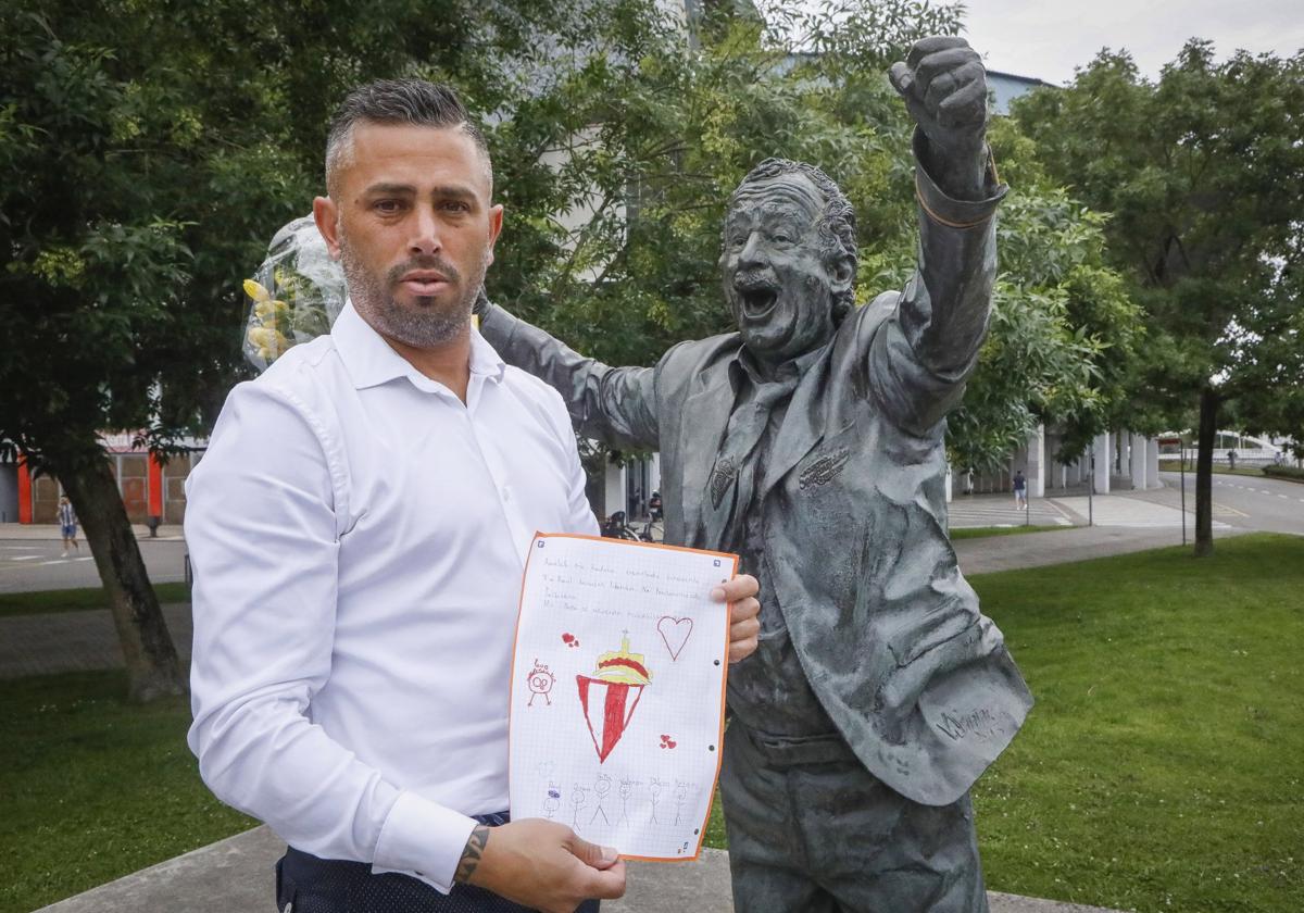 Nuevo homenaje.Manu Preciado, junto a la estatua de su padre en El Molinón y un dibujo de su hija Valeria.