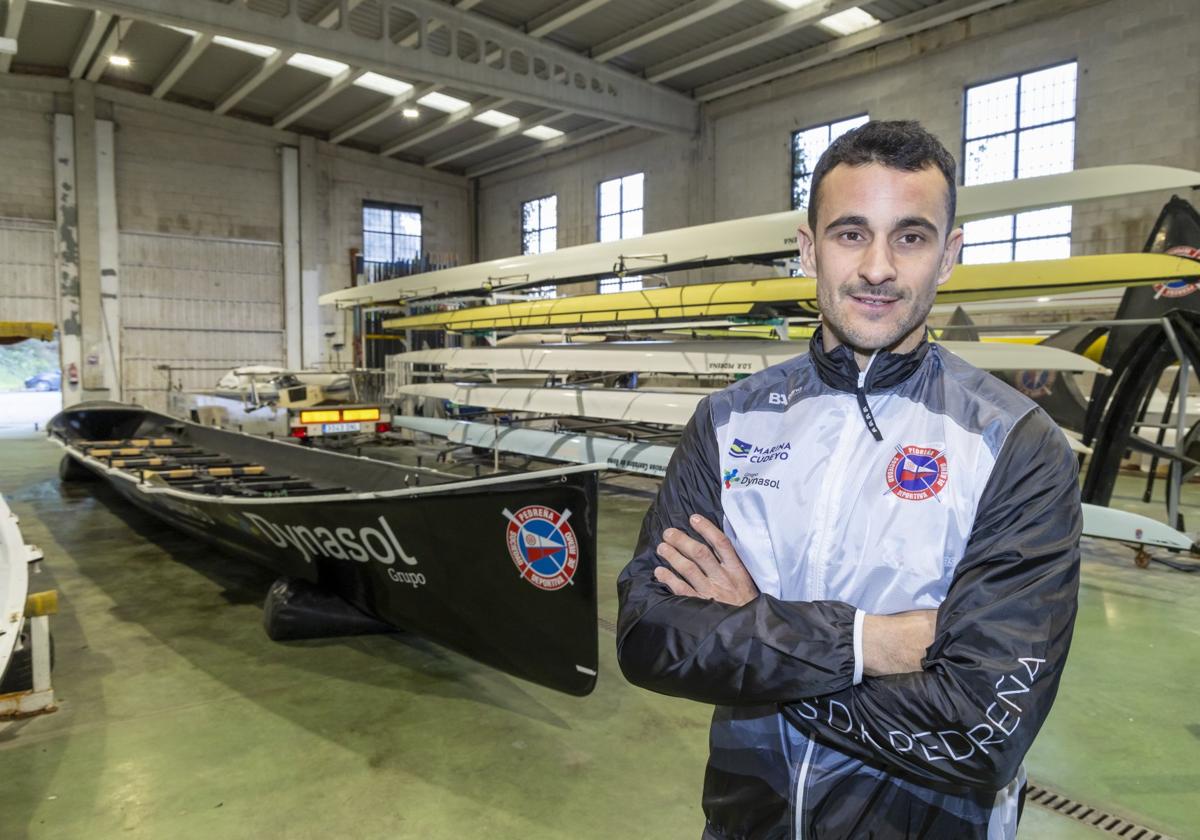 Luismi Villar posa junto a la trainera en la nave de Pedreña.