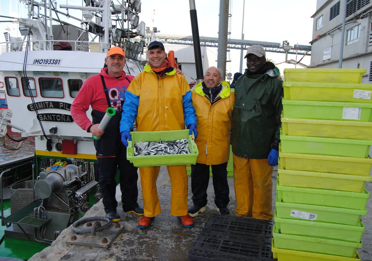 Pescadores del barco Ermita Pilar muestran el bocarte descargado en el puerto de Santoña.