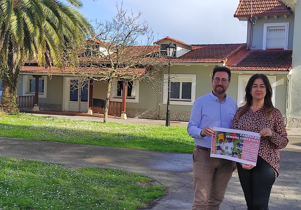 El alcalde de Colindres, Javier Incera, y la concejal de Infancia, Aracelia Ayesa, posan junto al cartel del campus.