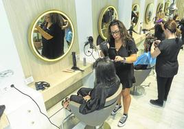 Varias peluqueras atienden a sus clientas en una peluquería de Santander.