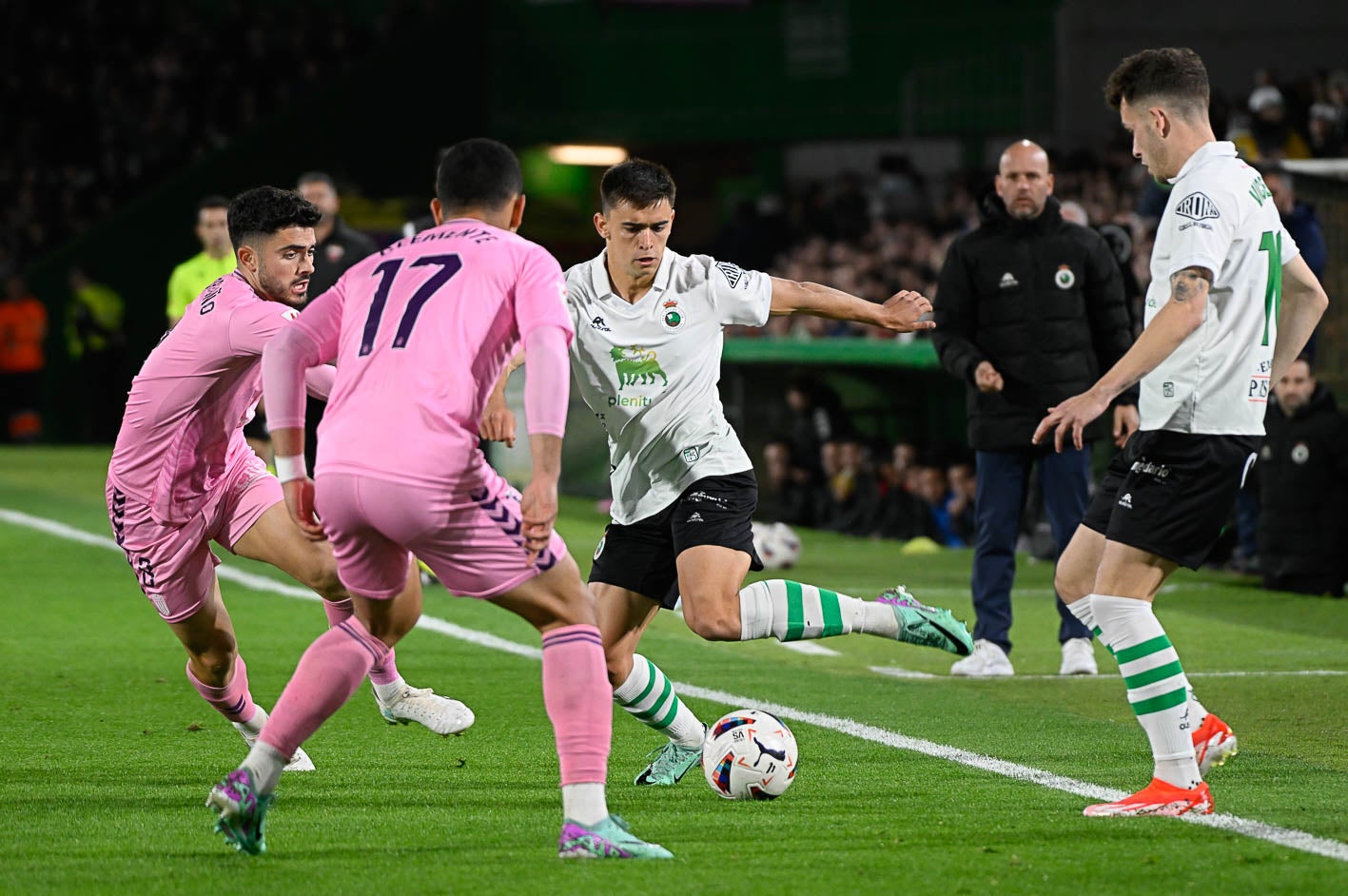 El lateral izquierdo Mario García protege la pelota ante dos jugadores del Eldense. 