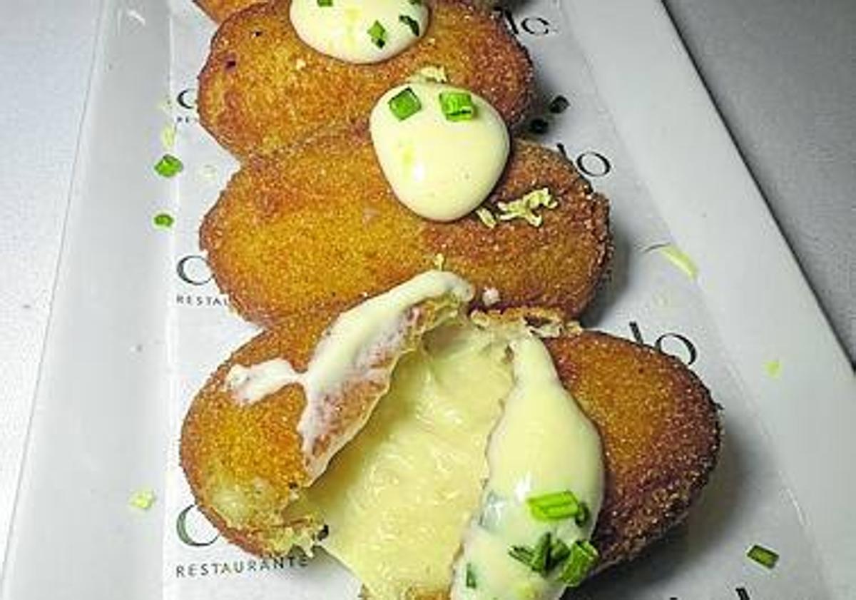 Imagen principal - Arriba, croquetas de bacalao. A la izquierda, patatas bravas con salsa y, a la derecha, bizcocho de maíz, helado y queso.