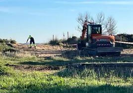 Operarios de Costas retirando la pasarela de madera situada en la zona de El Barco.