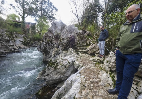 Un grupo de hombres contempla los lances de uno de los pescadores en el río Pas.