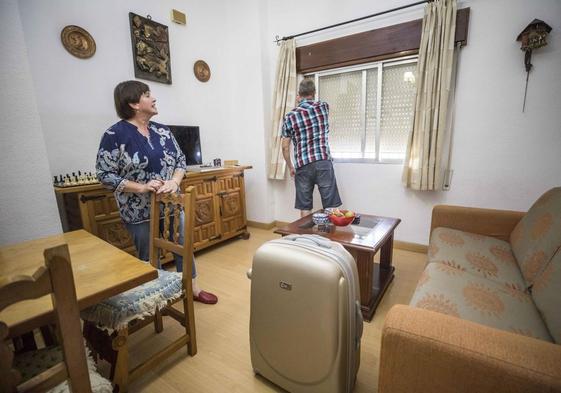 Una pareja llega a una vivienda de uso turístico con su equipaje.