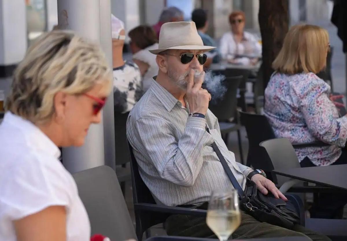 Un cliente fuma en una terraza.