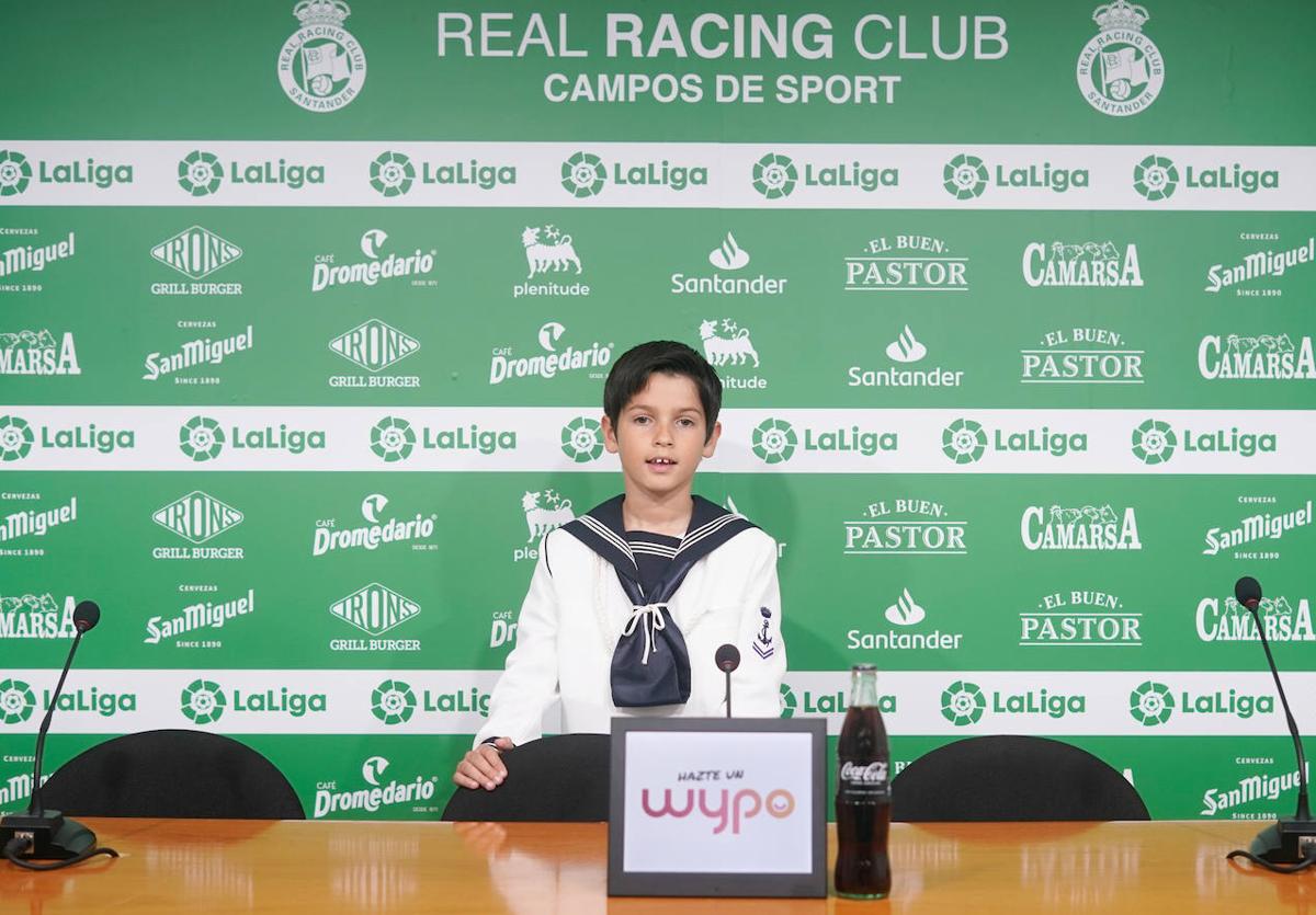 Un niño posando con su traje de marinero en la sala de prensa del Racing.