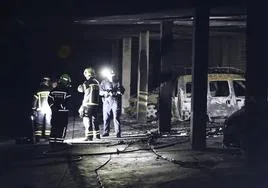 Los bomberos, inspeccionando el garaje arrasado después del incendio.