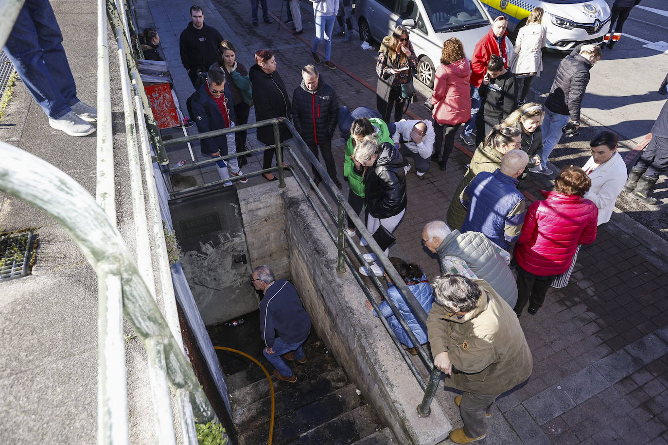 Los vecinos observan los daños asomados a una de las entradas del aparcamiento