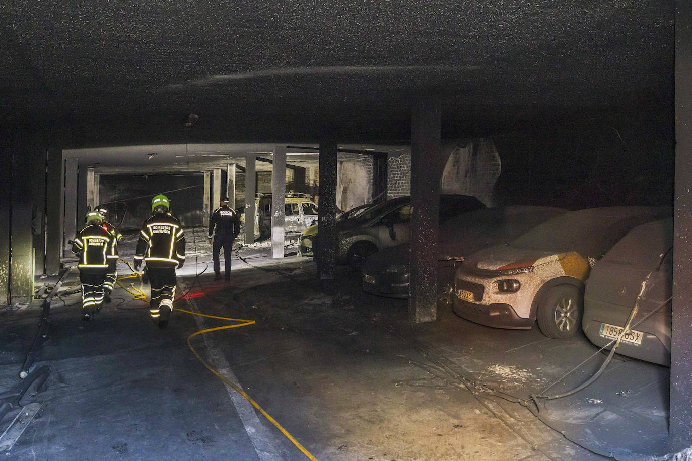 Los bomberos recorriendo el garaje por la mañana.