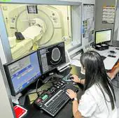 Personal sanitario controla la prueba de escáner realizada a un paciente en el Hospital Valdecilla.