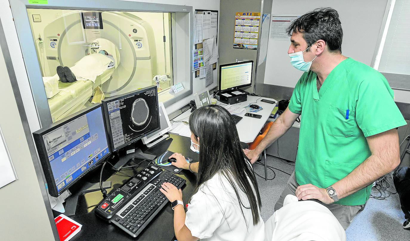 Personal sanitario controla la prueba de escáner realizada a un paciente en el Hospital Valdecilla.