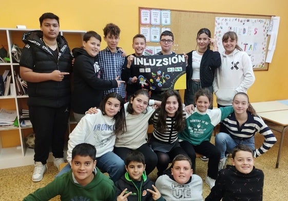 Los ganadores del concurso posan con el cartel.