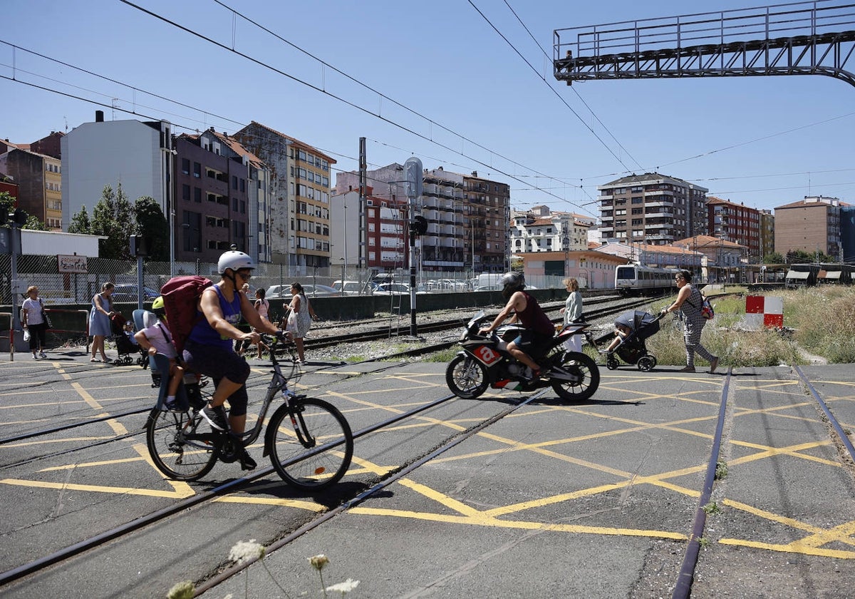 Vecinos cruzan el paso a nivel de Pablo Garnica, en Torrelavega.