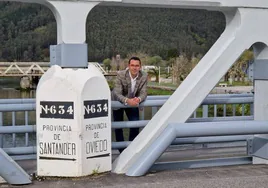 El alcalde de Val de San Vicente, Roberto Escobedo, posa en el puente sobre el río Deva que separa Asturias y Cantabria.