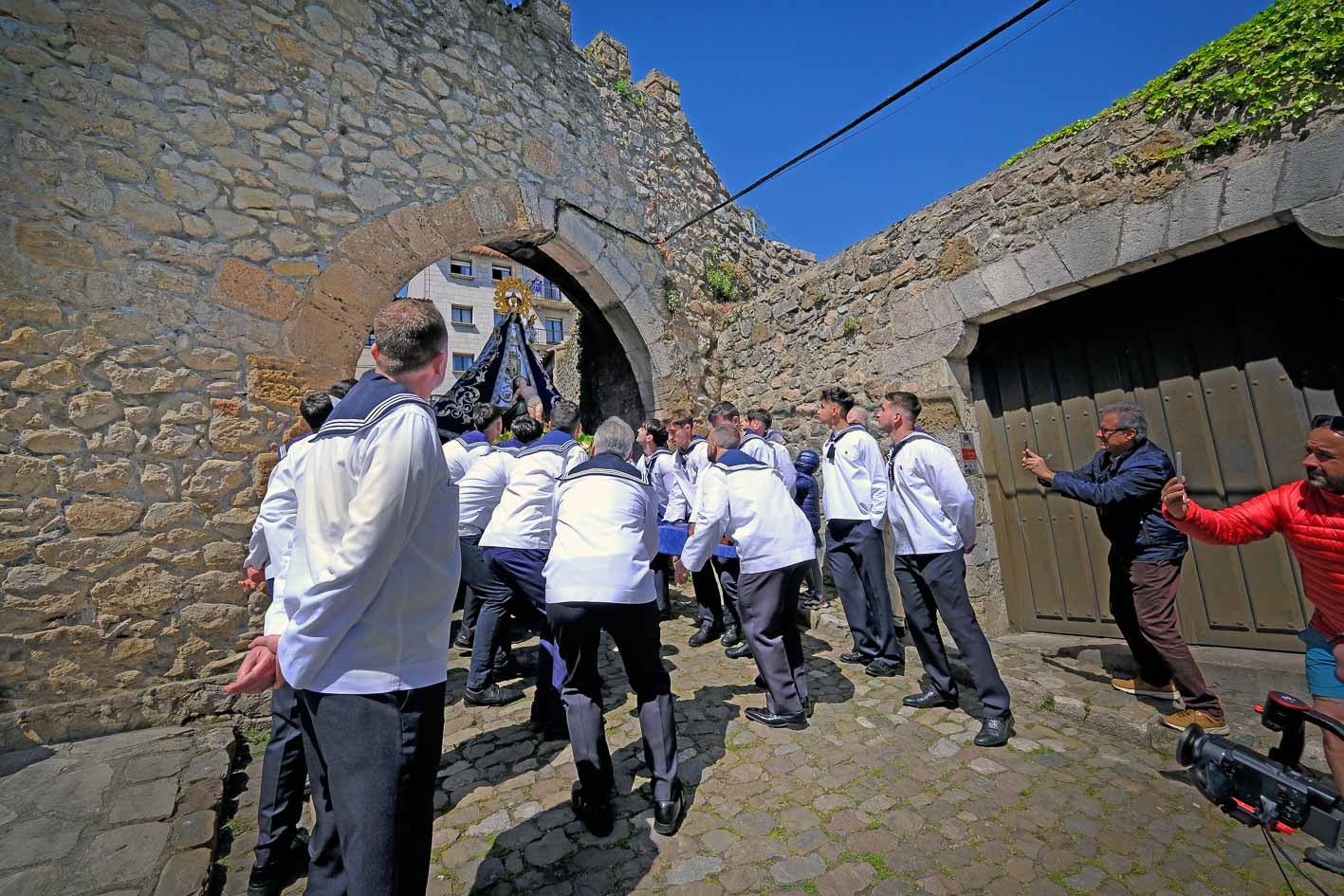 Los picayos llevan la imagen de la Virgen bajo una de las puertas de las antiguas murallas de San Vicente.