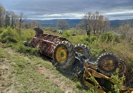 Imagen del tractor con el remolque volcado en el lugar del accidente.