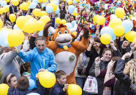 Los asistentes agitan los globos al ritmo de la música y el confeti en plena ebullición de la fiesta.