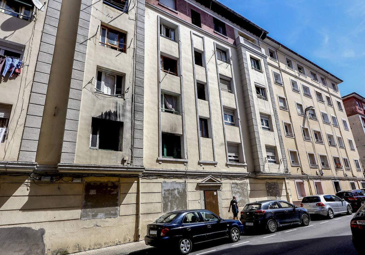 Un vecino camina frente al número 9 de la calle Marqueses de Valdecilla y Pelayo de La Inmobiliaria, en Torrelavega.