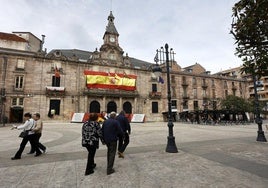 Vecinos caminan frente al Palacio municipal de Torrelavega, consolidado estructuralmente el año pasado.