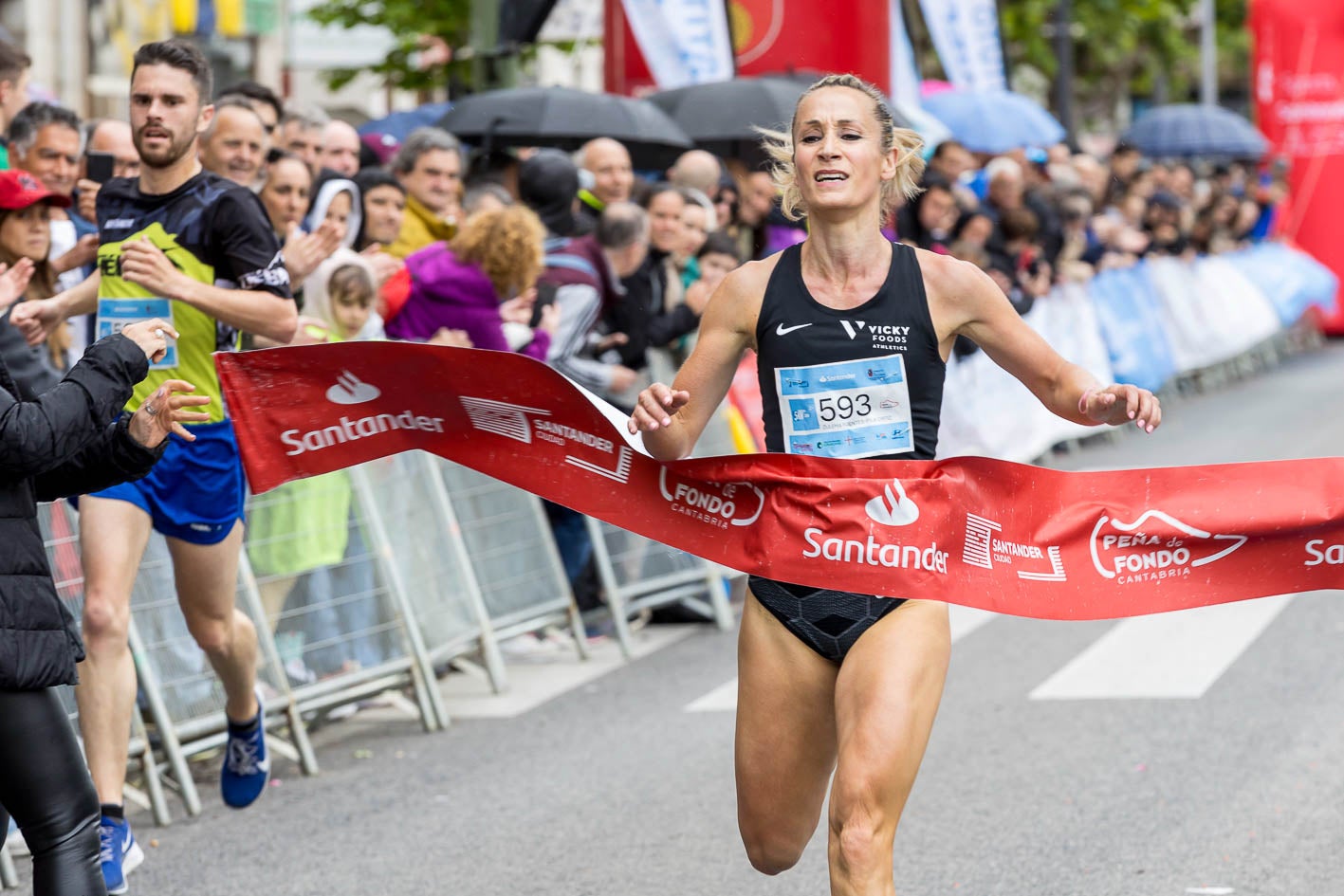 Zulema Fuentes-Pila cruza la línea de meta como ganadora femenina de los cinco kilómetros.