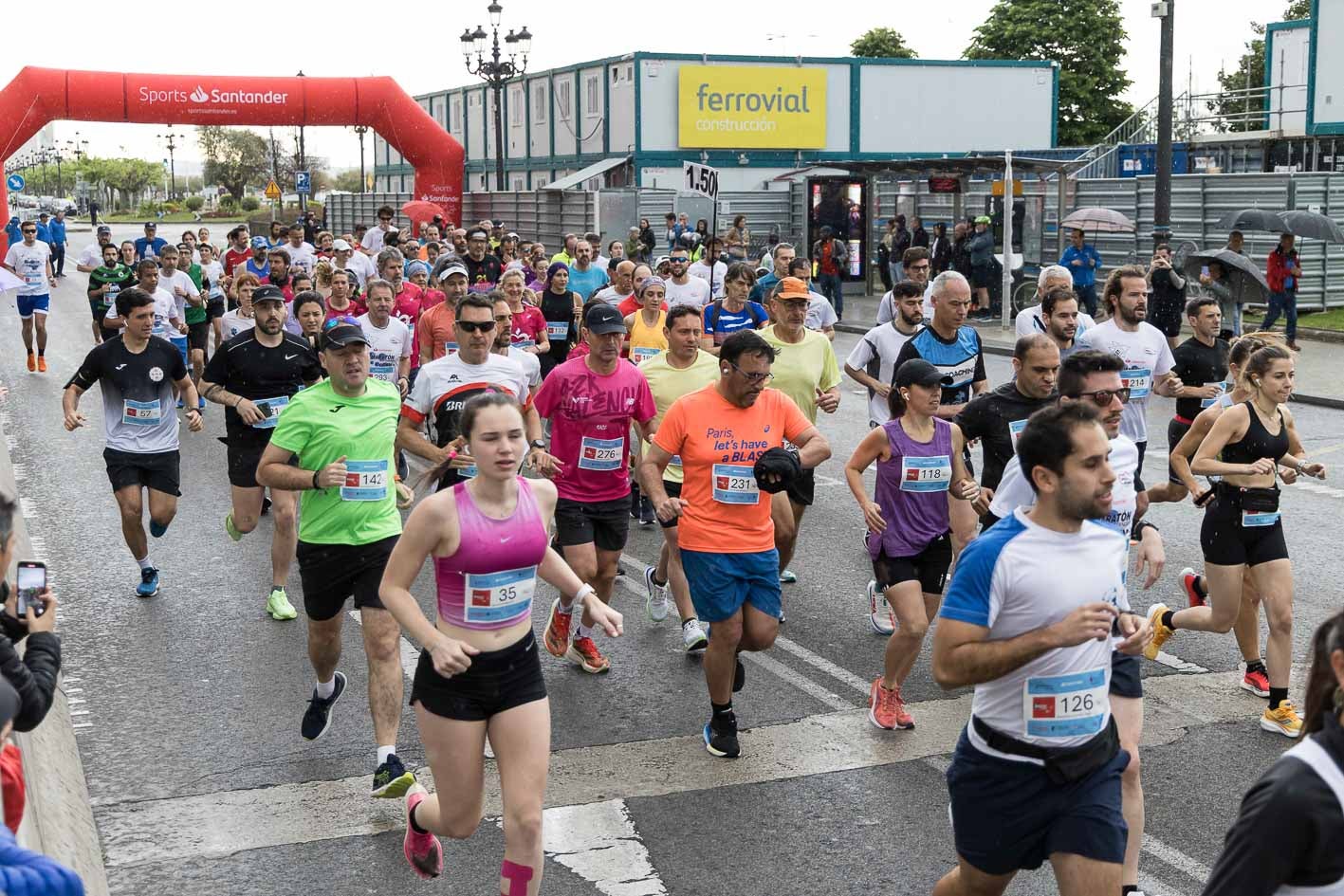 Los atletas que cierran el grupo en la media maratón, tras pasar por el arco de salida.