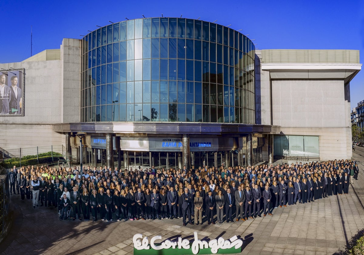 Foto de familia con parte de la plantilla de El Corte Inglés, posando en la entrada del centro comercial, en Nueva Montaña.