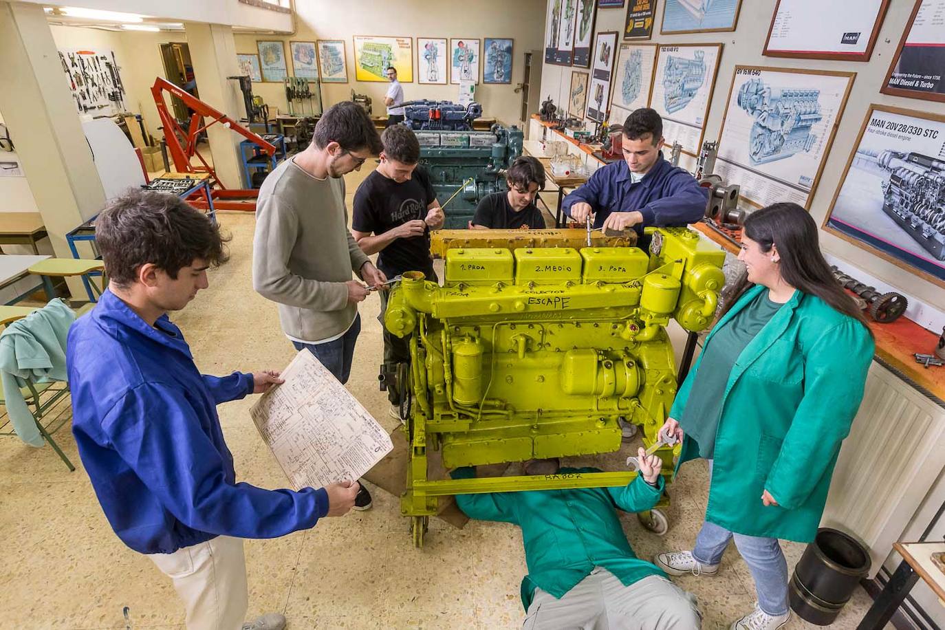 Varios alumnos de la ETS de Náutica, en Santander, trabajan con una de las máquinas de la Escuela. 