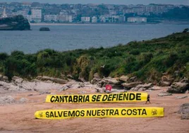 La pancarta gigante se  ha desplegado en la isla Santa Marina, frente a Loredo.