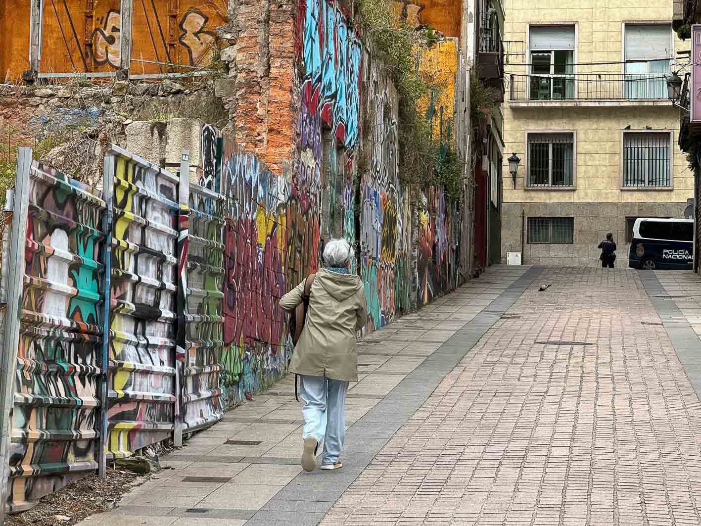 Una señora asciende por la calle San Pedro, en el Cabildo de Arriba, lleno de grafitis