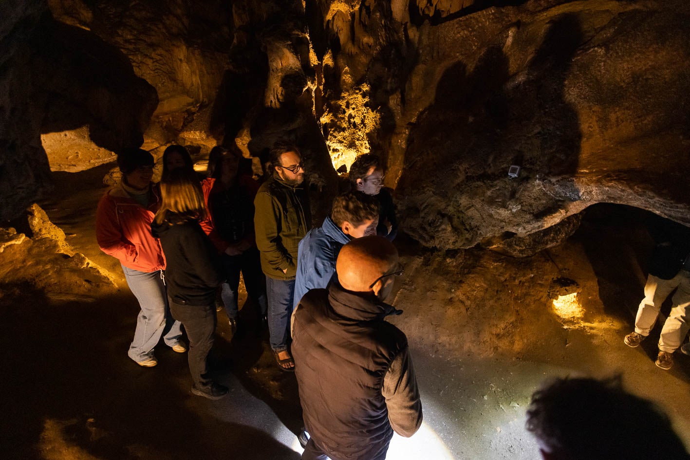 Visitantes en la cueva de El Castillo atienden las explicaciones del guía.