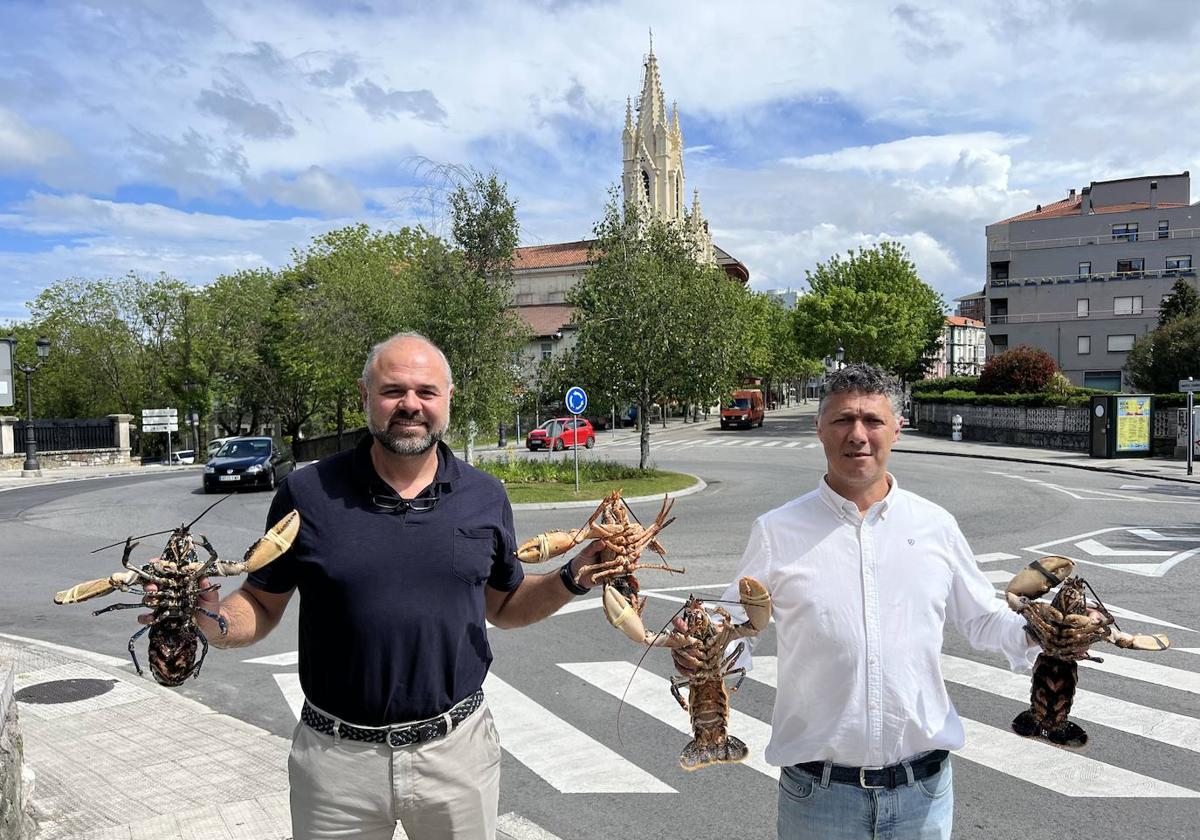 Miguel Ángel Cuartas Constanzo y Cristian Peramato sostienen unos ejemplares de bogavante azul.