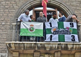 Aficionados y autoridades colocando las banderas en el balcón de Alcaldía.