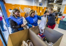 Una señora colabora en la recogida de alimentos en el Lupa de la calle Calderón de la Barca en Santander.