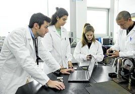 Alejandro López, a la izquierda, trabaja junto a su equipo con pequeñas baterías de ion de litio, colocadas sobre la mesa.